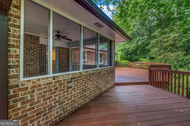 2585 Regency Dr E, Tucker, GA 30084 - wooden deck with ceiling fan and a sunroom