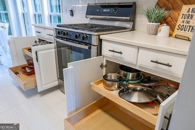 1805 Millstone Ct, Alpharetta, GA 30004 - kitchen with stainless steel range with gas cooktop, tasteful backsplash, white cabinets, and light countertops