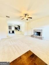 113 Truman Ct, Jackson, GA 30233 - unfurnished living room with a fireplace with raised hearth, wood finished floors, and a ceiling fan