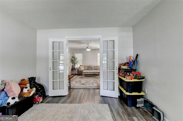 5385 Spotted Fawn Ct, Suwanee, GA 30024 - doorway with french doors, wood finished floors, a ceiling fan, and a textured ceiling