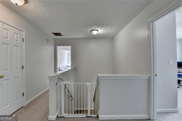 5385 Spotted Fawn Ct, Suwanee, GA 30024 - hall featuring an upstairs landing, a textured ceiling, and carpet flooring