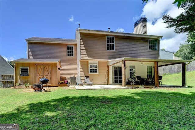 5385 Spotted Fawn Ct, Suwanee, GA 30024 - back of house with a chimney, a patio, a shed, and a lawn