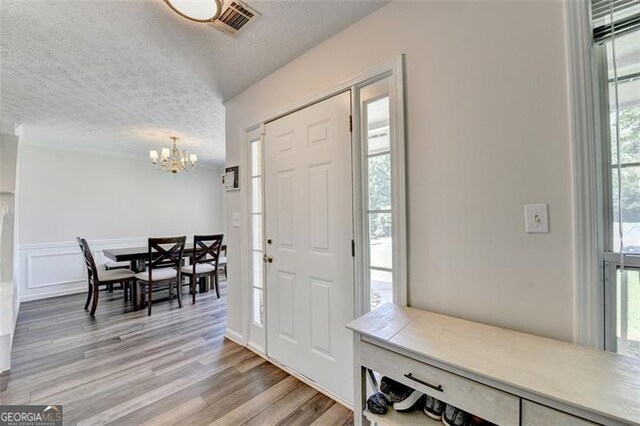 5385 Spotted Fawn Ct, Suwanee, GA 30024 - foyer entrance with a chandelier, a textured ceiling, and light wood-style floors