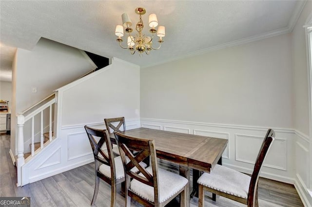 5385 Spotted Fawn Ct, Suwanee, GA 30024 - dining area with wood finished floors, stairs, a chandelier, a decorative wall, and wainscoting