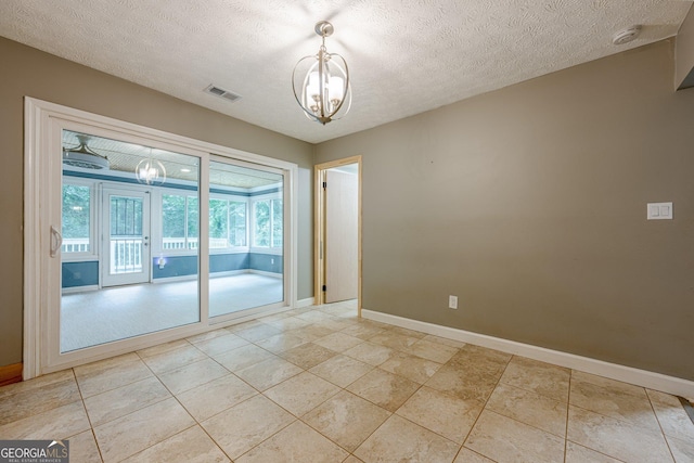5868 Kingswood Ct NW, Norcross, GA 30093 - empty room with a chandelier, a smoke detector, a textured ceiling, and light tile patterned floors