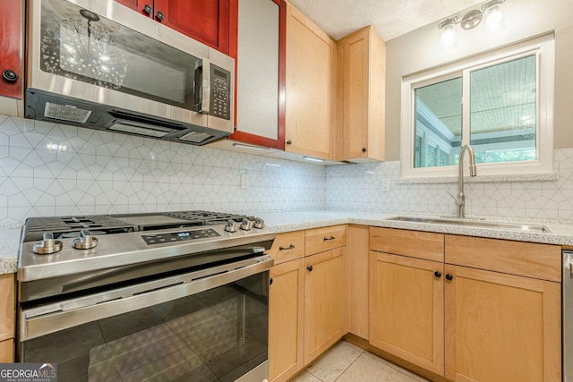 5868 Kingswood Ct NW, Norcross, GA 30093 - kitchen with stainless steel appliances, light brown cabinetry, backsplash, light tile patterned floors, and a textured ceiling