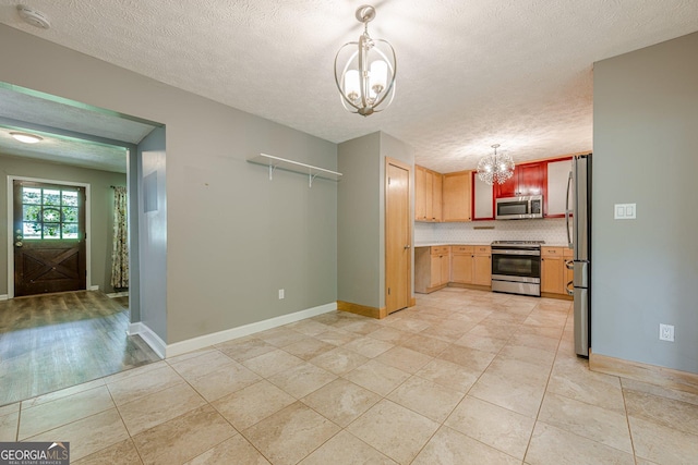 5868 Kingswood Ct NW, Norcross, GA 30093 - kitchen with appliances with stainless steel finishes, a chandelier, light countertops, tasteful backsplash, and decorative light fixtures