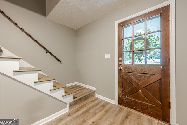 5868 Kingswood Ct NW, Norcross, GA 30093 - doorway with light wood-style flooring, stairs, and a textured ceiling