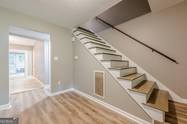 5868 Kingswood Ct NW, Norcross, GA 30093 - staircase with wood finished floors and a textured ceiling
