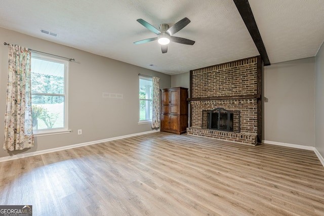 5868 Kingswood Ct NW, Norcross, GA 30093 - unfurnished living room with wood finished floors, a textured ceiling, a ceiling fan, and a fireplace