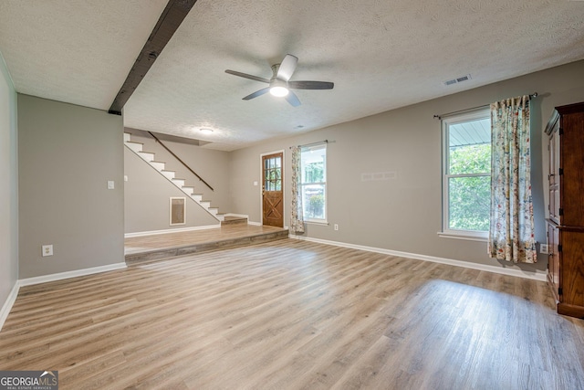 5868 Kingswood Ct NW, Norcross, GA 30093 - unfurnished living room with a textured ceiling, light wood-style floors, stairs, and a ceiling fan