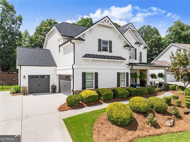 2213 Independence Ln, Buford, GA 30519 - modern farmhouse style home with a standing seam roof, concrete driveway, a garage, a metal roof, and a shingled roof