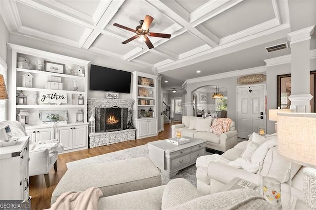 2213 Independence Ln, Buford, GA 30519 - living area featuring decorative columns, wood finished floors, a stone fireplace, ceiling fan, and beam ceiling