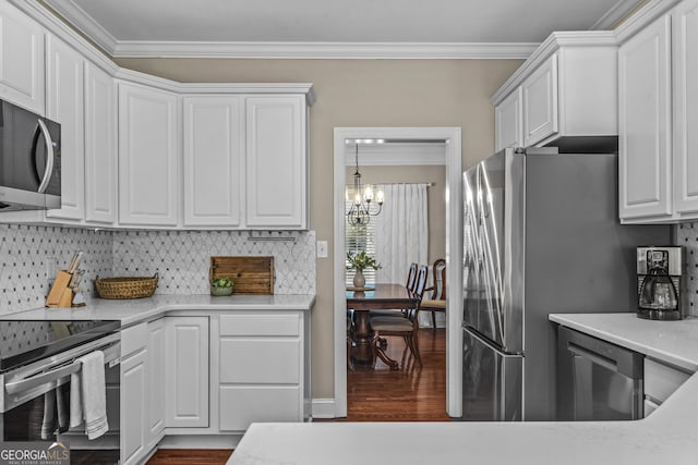 1120 Liberty Ln, Bogart, GA 30622 - kitchen with crown molding, appliances with stainless steel finishes, dark wood-style flooring, a chandelier, and white cabinetry