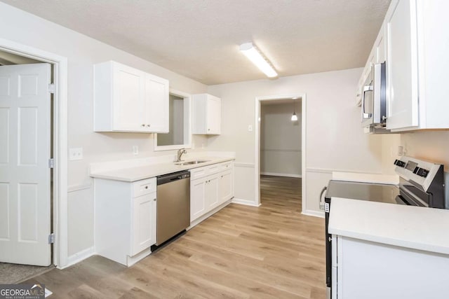 1024 Stone Mill Run, Lawrenceville, GA 30046 - kitchen featuring appliances with stainless steel finishes, light wood-style flooring, white cabinets, light countertops, and a textured ceiling