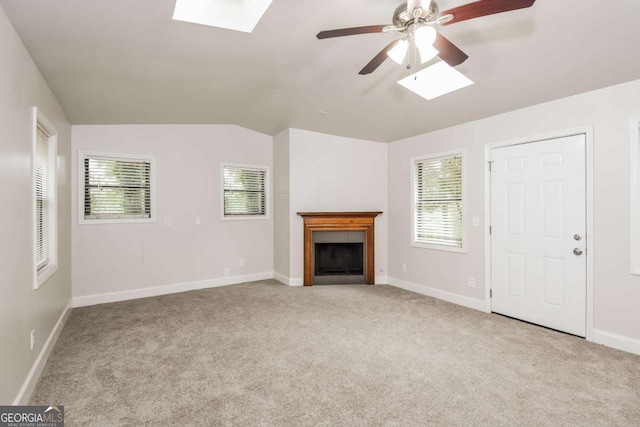 1024 Stone Mill Run, Lawrenceville, GA 30046 - unfurnished living room featuring a skylight, carpet flooring, a ceiling fan, a tiled fireplace, and vaulted ceiling