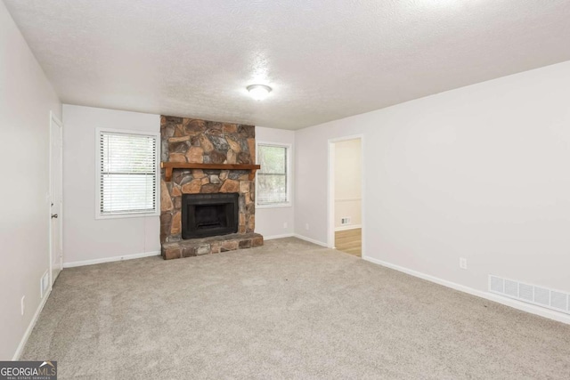 1024 Stone Mill Run, Lawrenceville, GA 30046 - unfurnished living room with a textured ceiling, a fireplace, and carpet