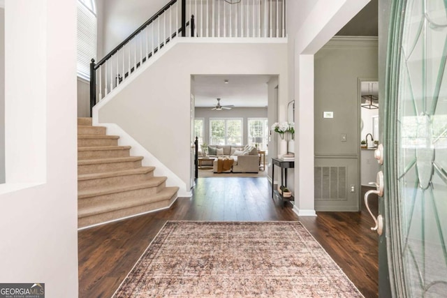2000 Settindown Dr, Roswell, GA 30075 - entryway with wood finished floors, stairs, ceiling fan, a high ceiling, and crown molding