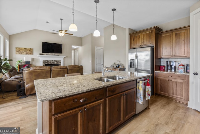 206 Barnyard Way, Perry, GA 31069 - kitchen with stainless steel appliances, vaulted ceiling, light wood finished floors, a ceiling fan, and a brick fireplace