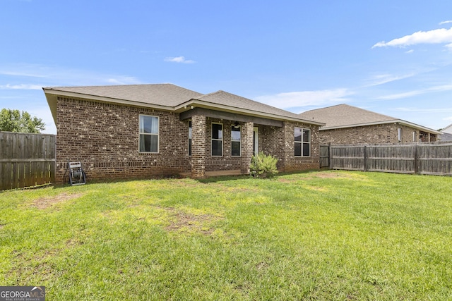 206 Barnyard Way, Perry, GA 31069 - back of house with brick siding, a fenced backyard, and roof with shingles