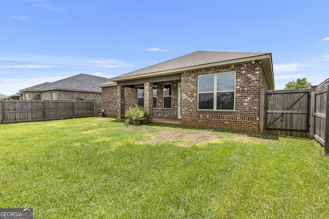 206 Barnyard Way, Perry, GA 31069 - back of property featuring brick siding, a fenced backyard, a gate, and a shingled roof