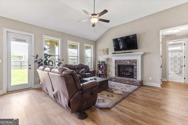 206 Barnyard Way, Perry, GA 31069 - living area with light wood finished floors, a ceiling fan, lofted ceiling, and a brick fireplace