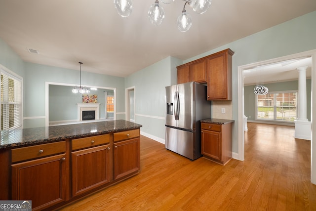 872 Misty View Ct, Lilburn, GA 30047 - kitchen with stainless steel refrigerator with ice dispenser, brown cabinetry, light wood-style flooring, a chandelier, and dark stone countertops