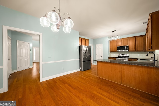 872 Misty View Ct, Lilburn, GA 30047 - kitchen with stainless steel appliances, a chandelier, dark wood-style floors, and a peninsula