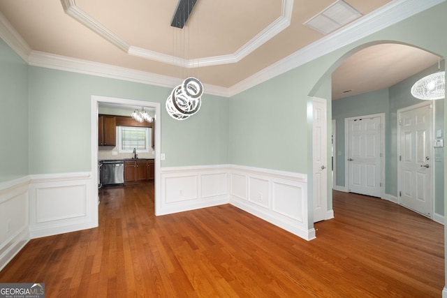 872 Misty View Ct, Lilburn, GA 30047 - unfurnished dining area featuring a chandelier, arched walkways, wood finished floors, ornamental molding, and a wainscoted wall