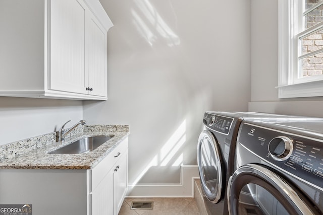 3047 Watsons Bnd, Milton, GA 30004 - laundry area featuring washing machine and dryer, cabinet space, and light tile patterned floors