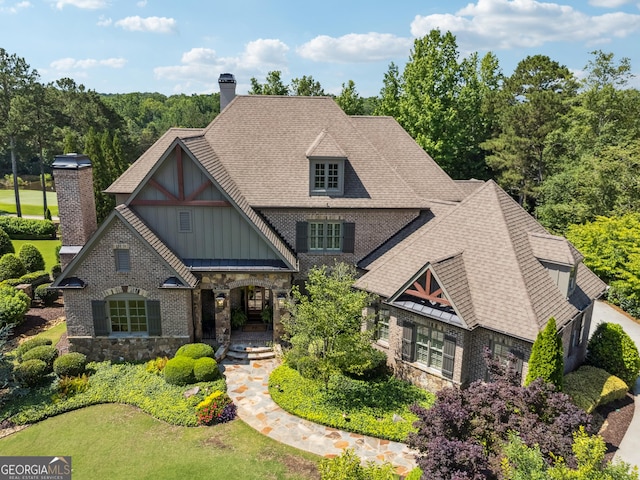 3047 Watsons Bnd, Milton, GA 30004 - view of front facade featuring board and batten siding, a chimney, stone siding, and a shingled roof
