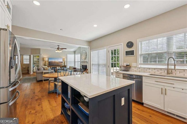 2508 Haddenham Ln SW, Smyrna, GA 30082 - kitchen with stainless steel appliances, white cabinets, a kitchen island, plenty of natural light, and recessed lighting
