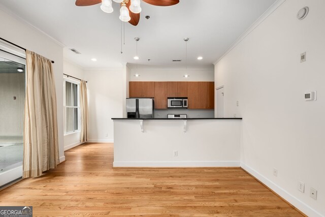 384 Ralph Mcgill Blvd NE Unit 123, Atlanta, GA 30312 - kitchen with appliances with stainless steel finishes, a ceiling fan, dark countertops, brown cabinetry, and a peninsula