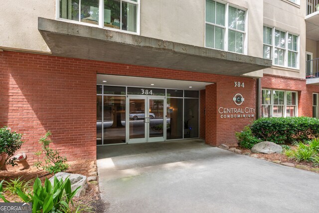 384 Ralph Mcgill Blvd NE Unit 123, Atlanta, GA 30312 - view of exterior entry with french doors, brick siding, and stucco siding