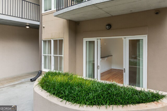 384 Ralph Mcgill Blvd NE Unit 123, Atlanta, GA 30312 - view of exterior entry featuring stucco siding, a balcony, and a security system