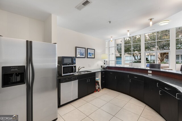 384 Ralph Mcgill Blvd NE Unit 123, Atlanta, GA 30312 - kitchen featuring appliances with stainless steel finishes, dark cabinets, light tile patterned flooring, and dark countertops