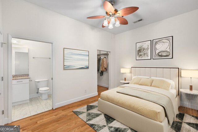 384 Ralph Mcgill Blvd NE Unit 123, Atlanta, GA 30312 - bedroom featuring a spacious closet, connected bathroom, ceiling fan, and light wood-style floors