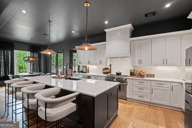 40 Fernbank Way, Newnan, GA 30265 - kitchen featuring stainless steel range, custom range hood, white cabinetry, an island with sink, and recessed lighting