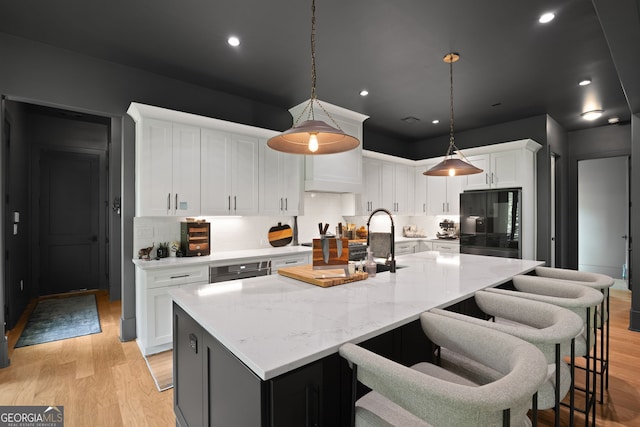 40 Fernbank Way, Newnan, GA 30265 - kitchen with refrigerator, backsplash, light wood-type flooring, a center island with sink, and recessed lighting