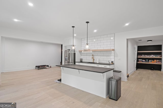 40 Fernbank Way, Newnan, GA 30265 - kitchen with dark countertops, decorative backsplash, stainless steel fridge with ice dispenser, light wood finished floors, and white cabinetry