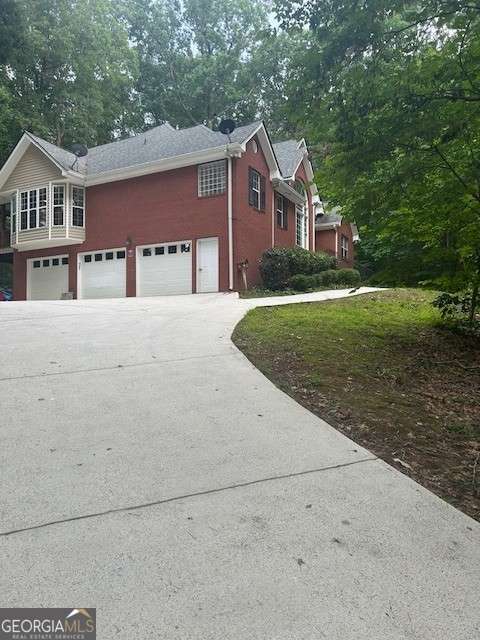 370 Butler Path, Dallas, GA 30132 - view of property exterior featuring driveway, an attached garage, and view of scattered trees