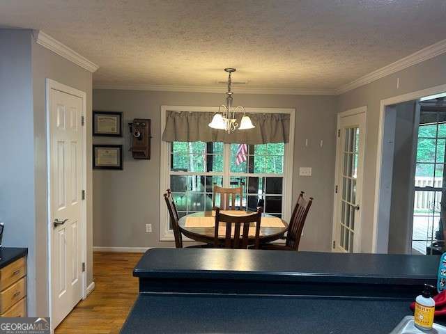 370 Butler Path, Dallas, GA 30132 - dining space with wood finished floors, a chandelier, ornamental molding, and a textured ceiling