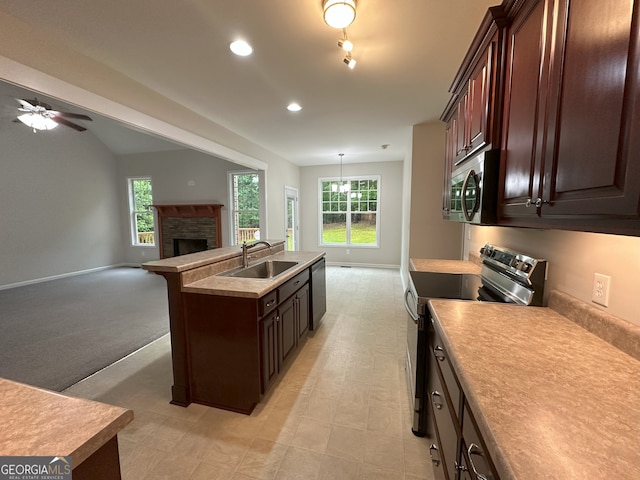 48 Narrow Ln, Dahlonega, GA 30533 - kitchen featuring appliances with stainless steel finishes, open floor plan, a center island with sink, a stone fireplace, and light countertops