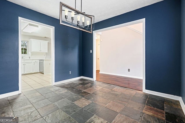 3366 English Oaks Dr NW, Kennesaw, GA 30144 - empty room featuring a chandelier, stone tile floors, and a textured ceiling