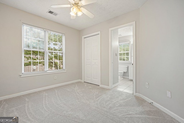 3366 English Oaks Dr NW, Kennesaw, GA 30144 - unfurnished bedroom with light colored carpet, multiple windows, a textured ceiling, a closet, and ensuite bathroom