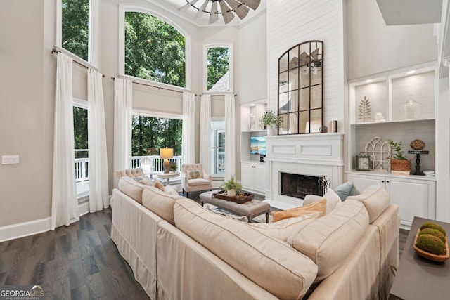 15305 Highgrove Rd, Milton, GA 30004 - living area with a towering ceiling, dark wood-type flooring, a fireplace, and healthy amount of natural light