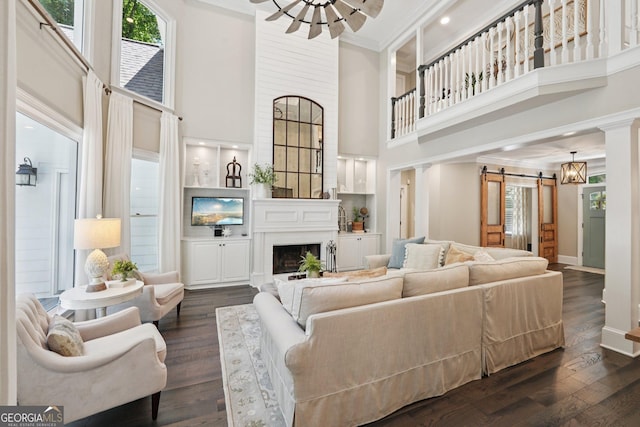 15305 Highgrove Rd, Milton, GA 30004 - living room with a barn door, a high ceiling, ornamental molding, a fireplace, and dark wood finished floors