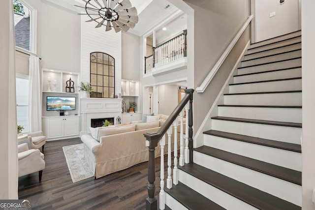 15305 Highgrove Rd, Milton, GA 30004 - living room with a towering ceiling, a chandelier, a fireplace, stairway, and dark wood-type flooring