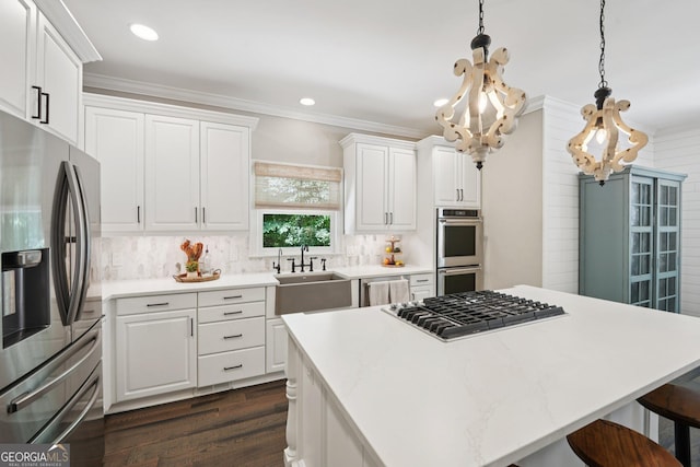 15305 Highgrove Rd, Milton, GA 30004 - kitchen with appliances with stainless steel finishes, ornamental molding, a breakfast bar, dark wood-type flooring, and white cabinetry