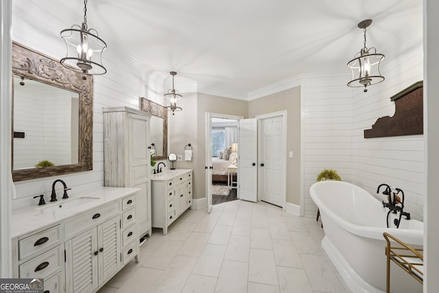 15305 Highgrove Rd, Milton, GA 30004 - ensuite bathroom featuring two vanities, a chandelier, a freestanding tub, ornamental molding, and marble finish floors